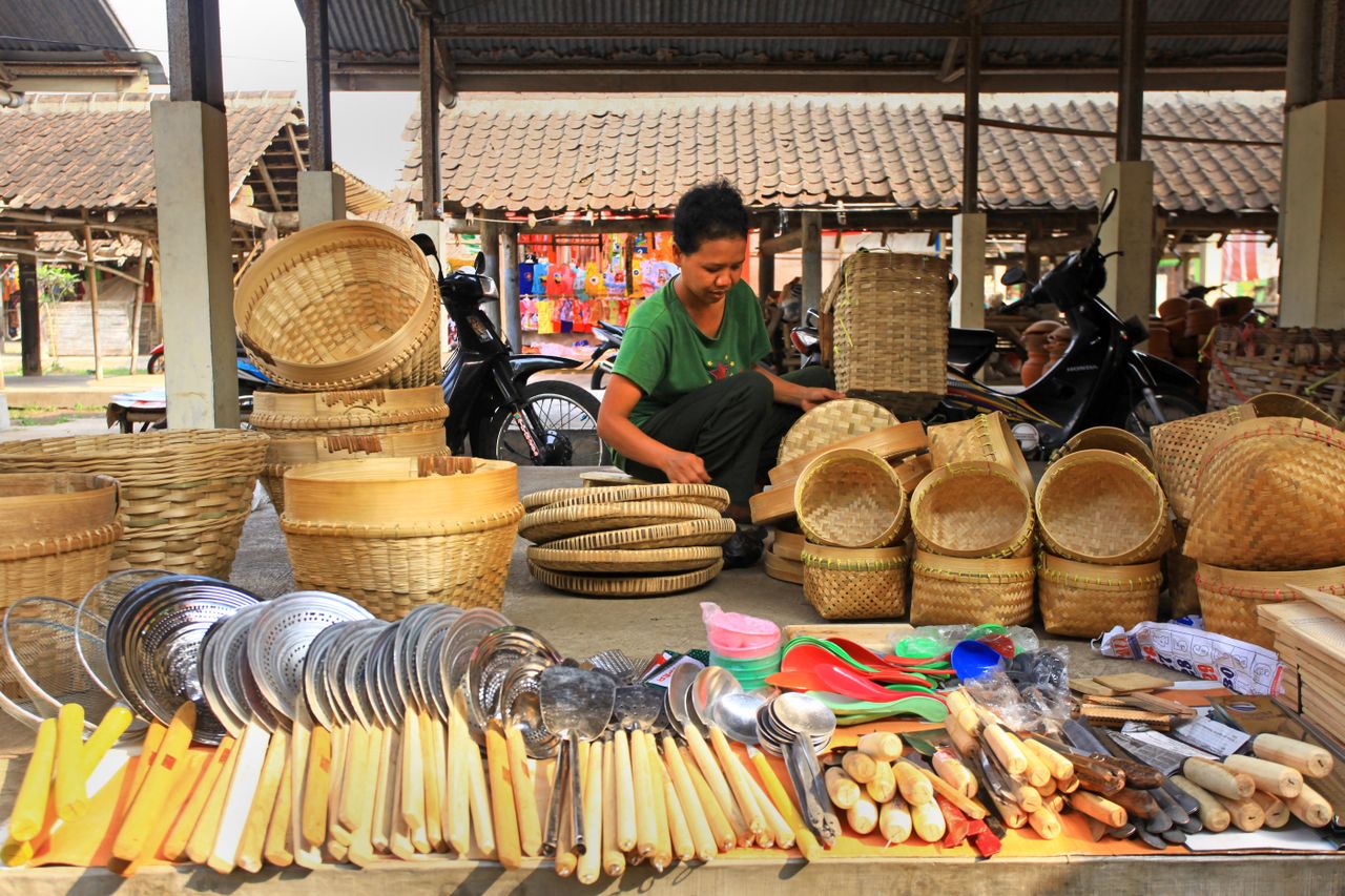 Home A vibrant market scene showcasing a stall of wicker baskets and utensils.