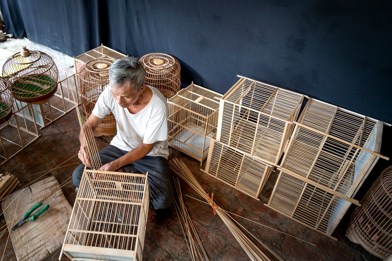 hero-img Skilled artisan weaving handmade wooden bird cages, showcasing traditional craftsmanship.